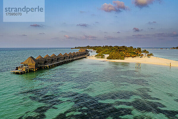 Malediven  Lhaviyani Atoll  Kuredu  Helikopterblick auf eine Reihe von Küstenbungalows im Morgengrauen