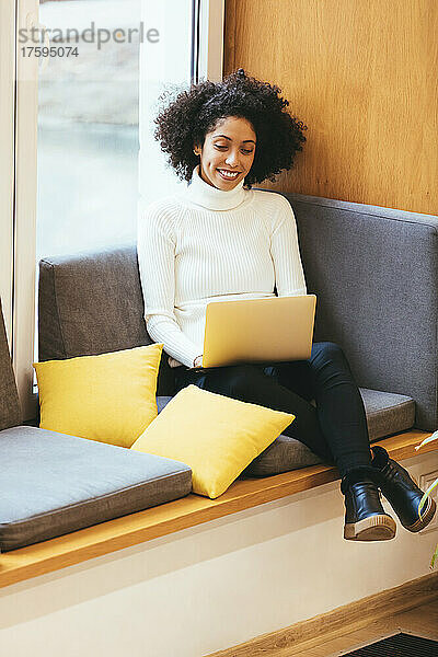 Geschäftsfrau arbeitet am Laptop auf dem Sofa