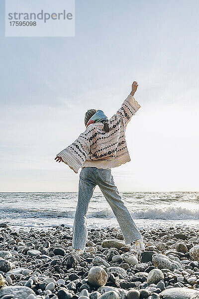Teenage girl with hand raised standing on shore at beach  Gagra  Abkhazia