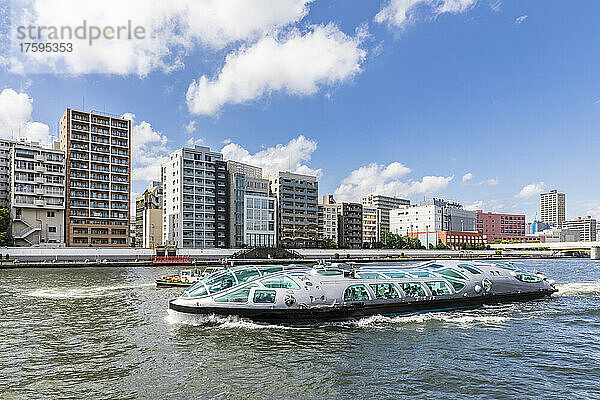 Japan  Kanto-Region  Tokio  modernes Ausflugsboot  das an Apartments am Flussufer vorbeifährt