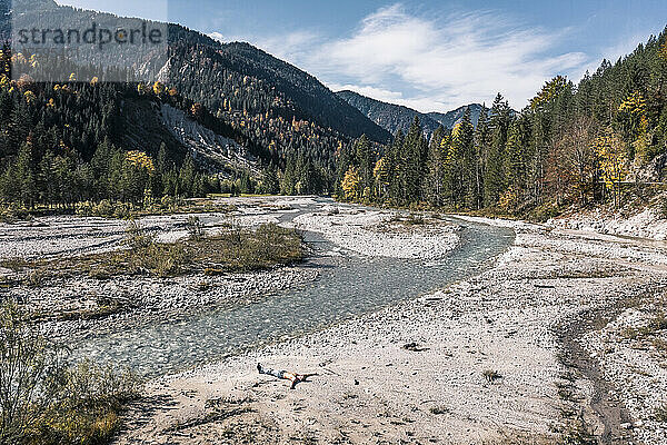 Man lying near Rissbach river in Hinterriss  Tyrol  Austria