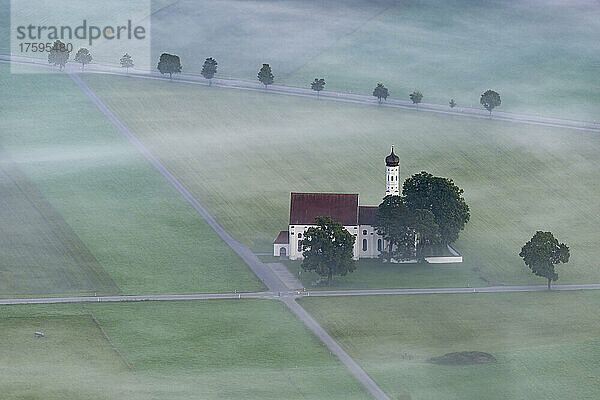 Germany  Bavaria  Fussen  Aerial view of Church of St. Coloman on foggy morning