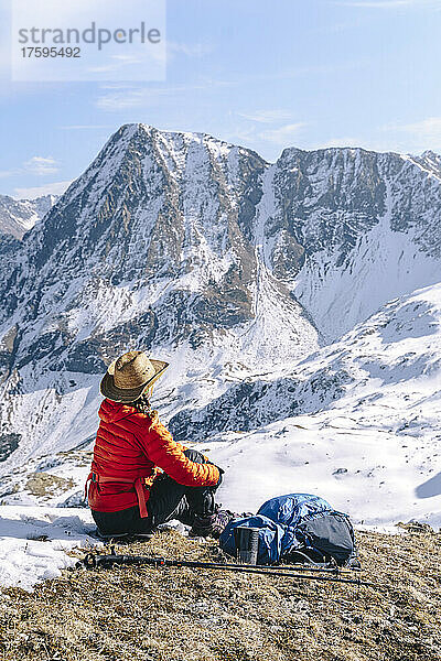 Frau in warmer Kleidung blickt auf schneebedeckte Berge  Naturschutzgebiet Kaukasus  Sotschi  Russland