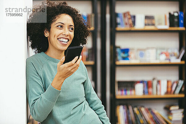 Happy businesswoman talking on smart phone in office
