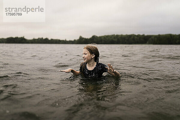 Mädchen mit braunen Haaren schwimmt im See