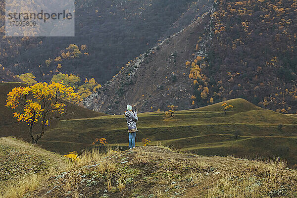 Frau steht auf einem terrassierten Feld an den Bergen im Nordkaukasus  Dagestan  Russland