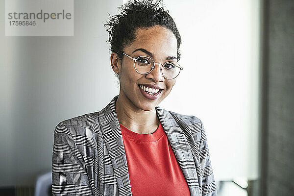 Lächelnde Geschäftsfrau mit Brille am Arbeitsplatz