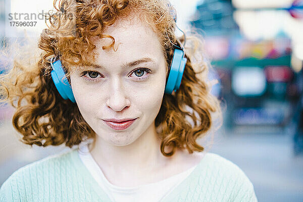 Junge Frau hört Musik über Kopfhörer