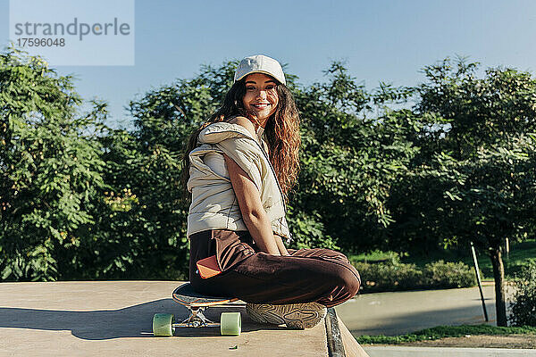 Lächelnde Frau auf Skateboard im Park