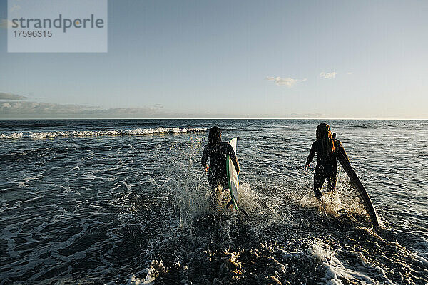 Frauen mit Surfbrettern wandern im Meer  Gran Canaria  Kanarische Inseln