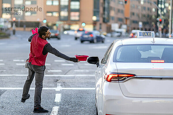 Künstler hält Hut mit dem Taxi auf der Straße in der Stadt