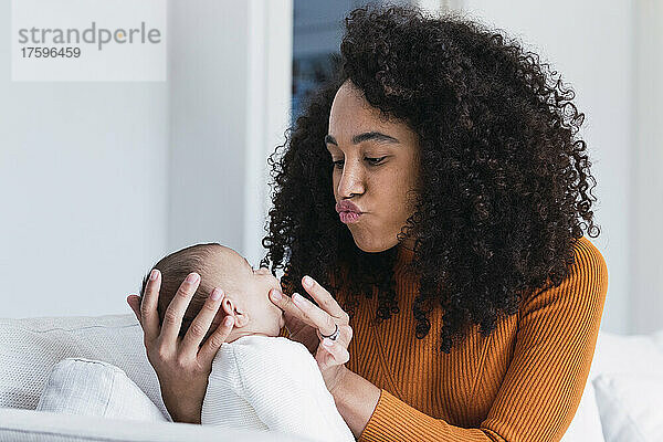 Mutter kräuselt sich und schaut ihren kleinen Jungen im Wohnzimmer an