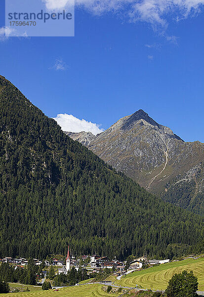 Österreich  Tirol  Sankt Sigmund im Sellrain  Luftaufnahme eines Dorfes am Fuße eines bewaldeten Berges im Sellraintal