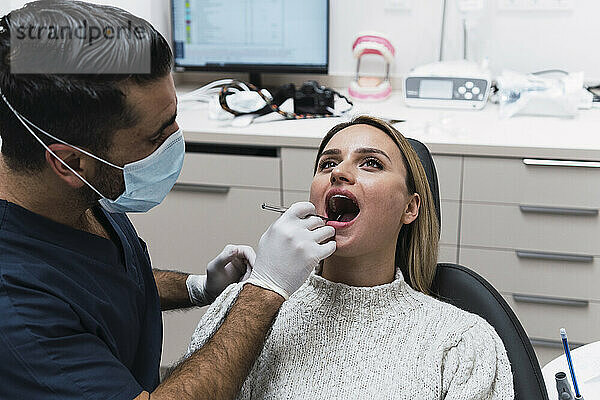 Zahnarzt analysiert Patientenzähne in der Klinik