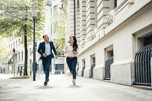 Geschäftsmann und Geschäftsfrau laufen auf Fußweg in der Stadt