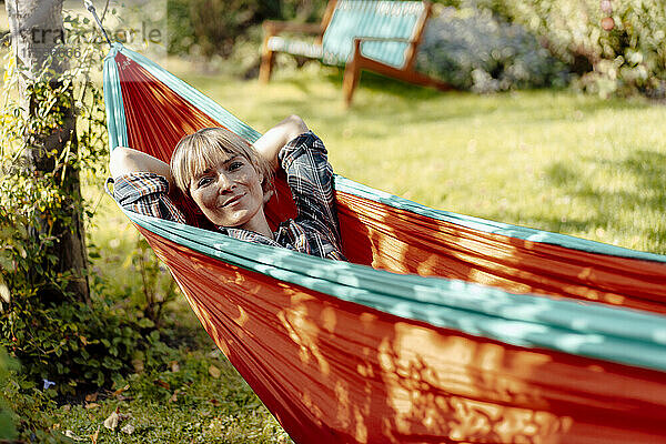 Woman with bangs resting in hammock