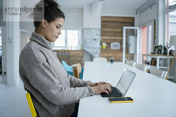 Vielbeschäftigter Freiberufler nutzt Tablet-PC am Schreibtisch im Büro