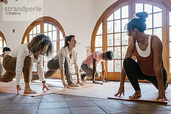 Lehrer schaut sich Schüler an  die im Yoga-Studio trainieren