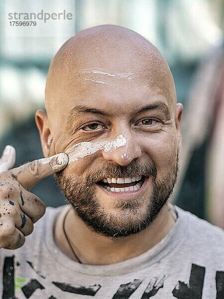 Artist applying paint on face