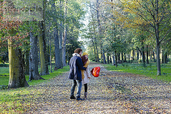 Glückliches Paar mit rotem Ballon  das im Park genießt