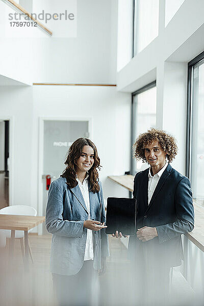 Lächelnder Geschäftsmann und Geschäftsfrau mit Tablet-PC im Büro