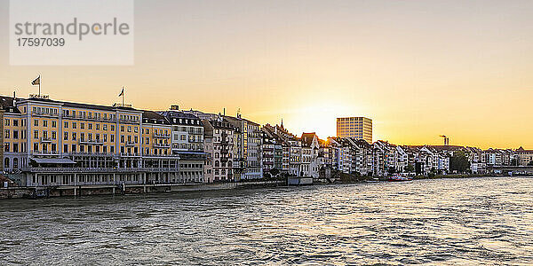 Schweiz  Basel-Stadt  Basel  Blick auf den Rhein bei Sonnenuntergang mit dem Hotel Les Trois Rois und Wohngebäuden im Hintergrund