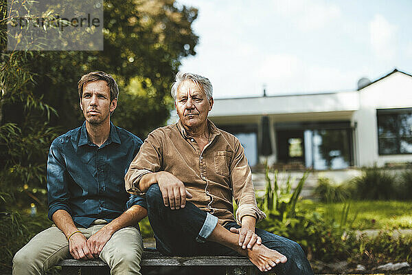 Vater und Sohn sitzen zusammen im Hinterhof