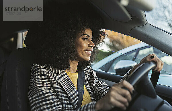 Lächelnde Frau fährt Auto auf Roadtrip