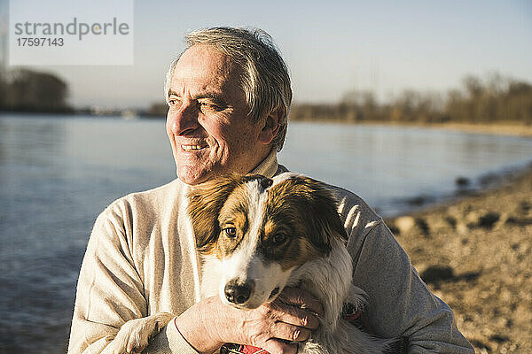 Happy man with pet dog on sunny day