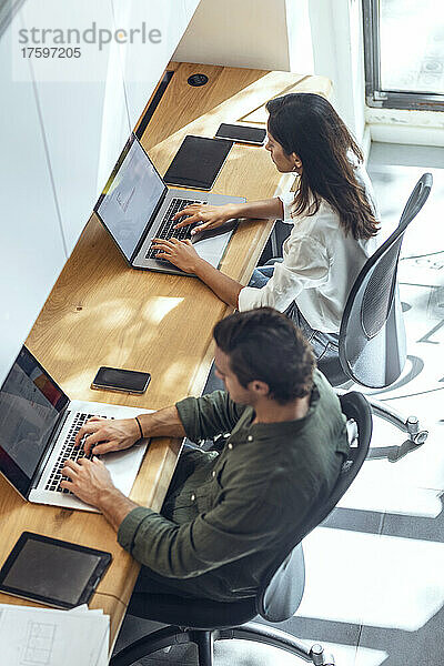 Geschäftsmann und Geschäftsfrau nutzen Laptops am Schreibtisch im Coworking-Büro