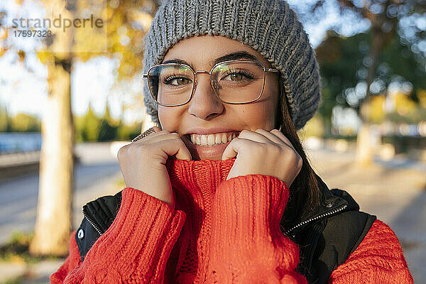 Smiling young woman wearing eyeglasses and knit hat