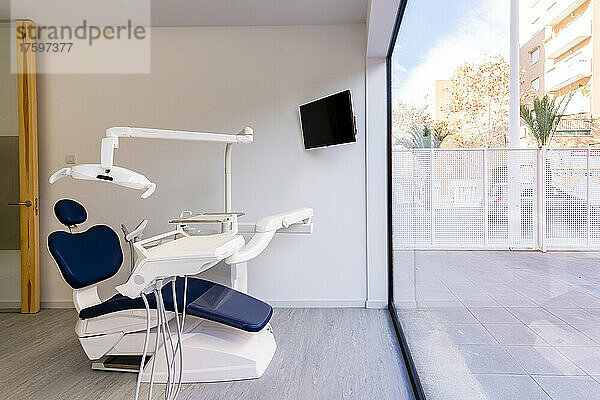 Zahnarztstuhl an einer Glaswand in einer medizinischen Klinik