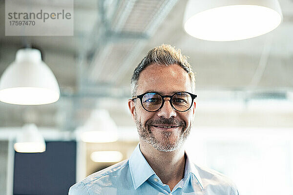 Smiling businessman wearing eyeglasses at office