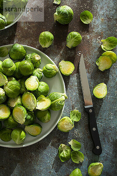 Kitchen knife and bowl of halved Brussels sprouts