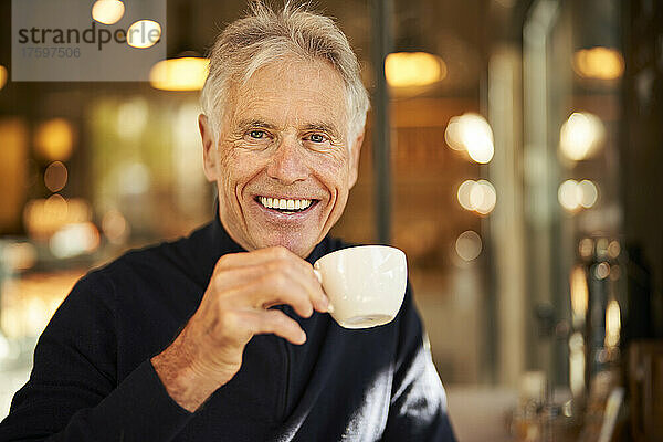 Elderly man with coffee cup in cafe