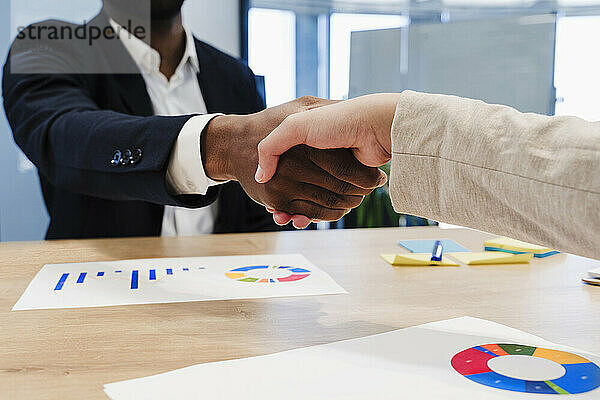 Geschäftskollegen schütteln sich nach einem Treffen im Coworking-Büro die Hand