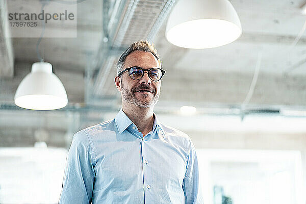 Smiling businessman wearing eyeglasses in office