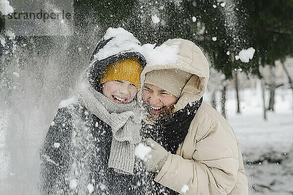 Fröhlicher Sohn und Mutter genießen den Schnee