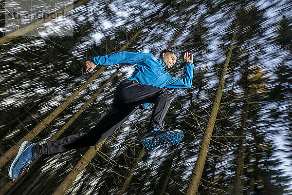 Active man jumping in forest