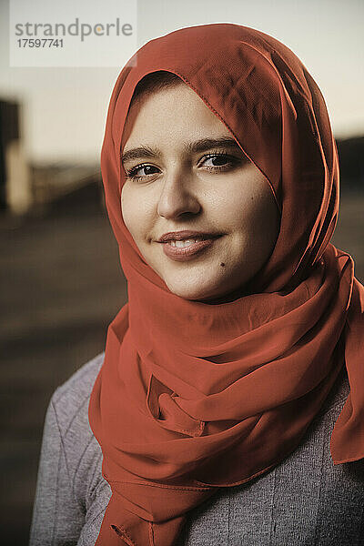 Lächelnde junge Frau mit rotem Hijab