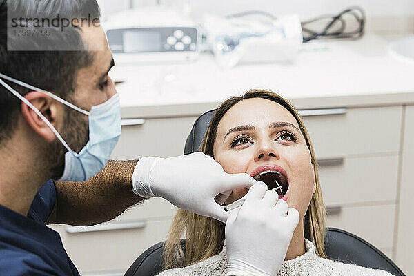 Zahnarzt untersucht die Zähne des Patienten in der Klinik