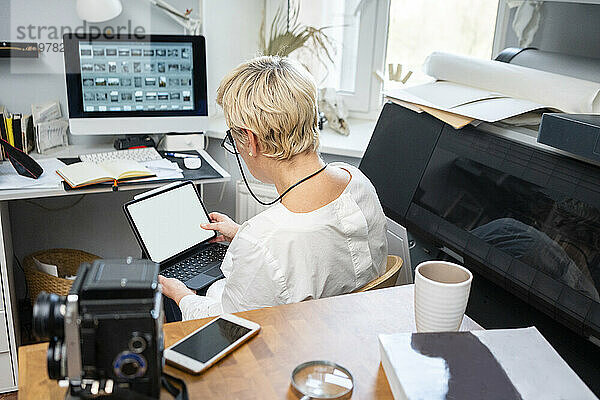 Blonde Frau benutzt Tablet-PC im Büro