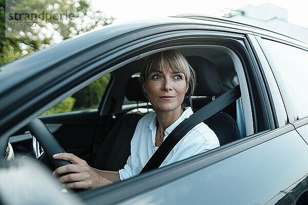 Nachdenkliche Frau fährt Auto auf Roadtrip