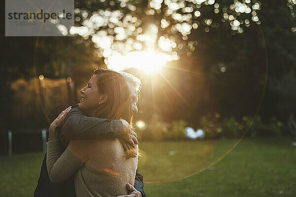 Zärtliches Paar umarmt sich bei Sonnenuntergang im Hinterhof