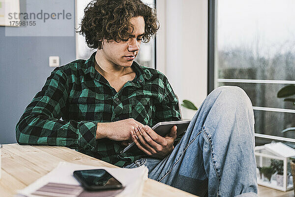 Junger Mann lernt zu Hause über Tablet-PC