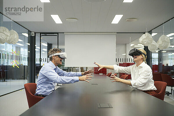 Kollegen sitzen mit VR-Brille am Konferenztisch im Büro