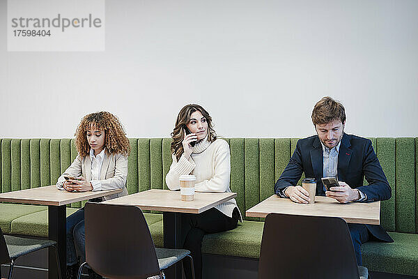 Geschäftsmann und Geschäftsfrauen sitzen in der Cafeteria