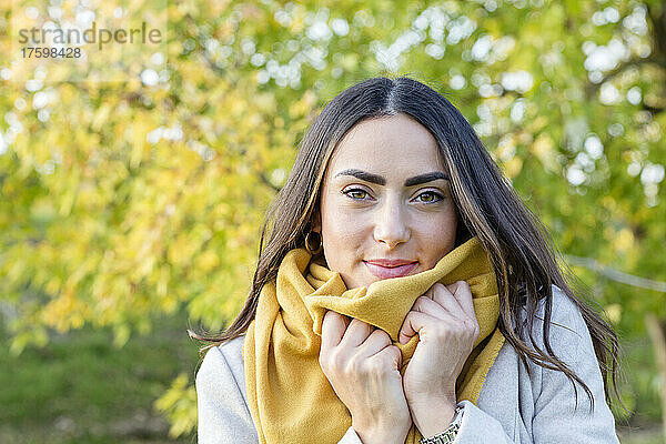 Schöne junge Frau mit gelbem Schal im Herbstpark
