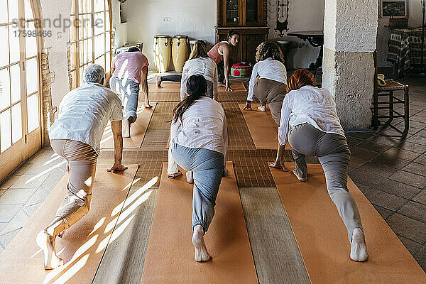 Freunde lernen Übung vom Lehrer im Yoga-Studio