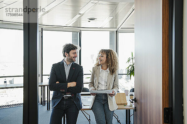 Lächelnder Geschäftsmann und Geschäftsfrau  die einander im Büro anschauen
